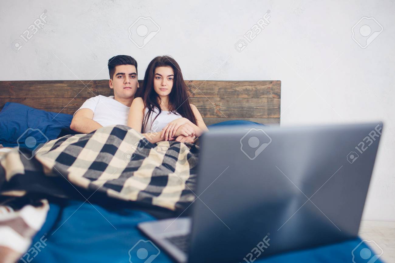 74884113 una pareja amorosa viendo una pelicula en una computadora portatil - Películas y series románticas para festejar este 14 de febrero